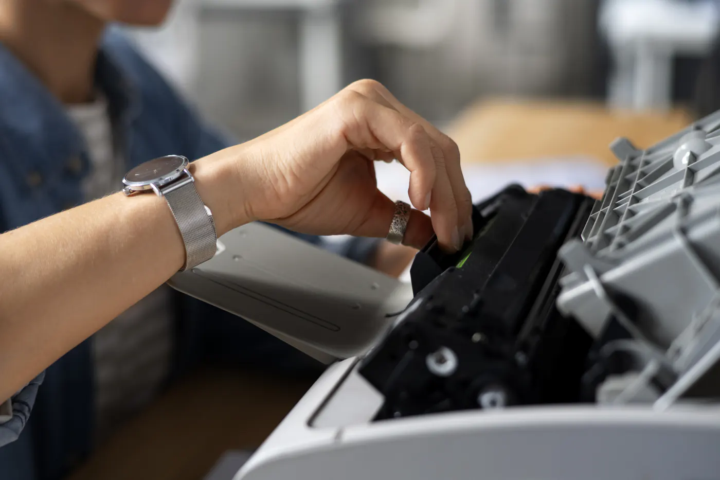 Close-up of a hand fitting a toner cartridge into a printer